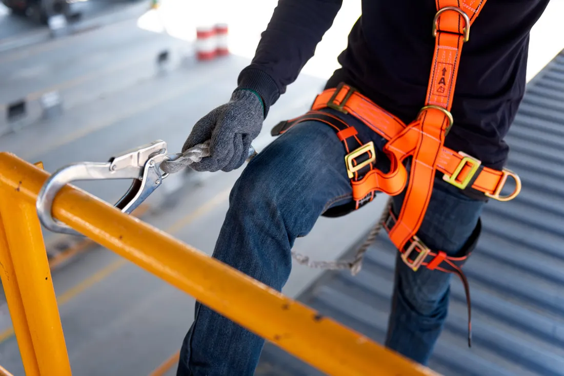 Worker wearing a safety harness on a worksite